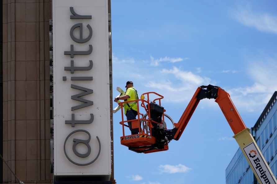 Worker removes old logo of Twitter from HQ