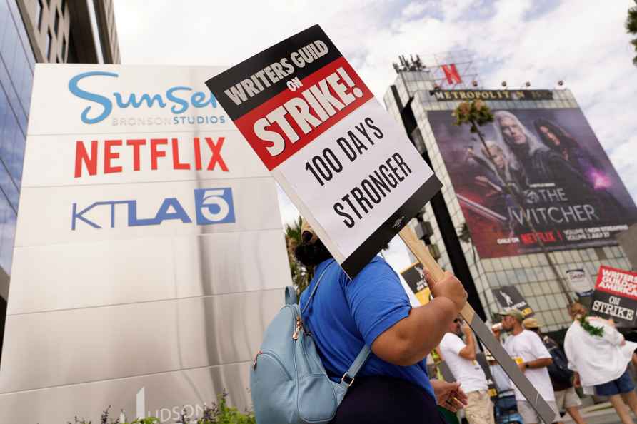 A picketer carries a sign outside Netflix studios