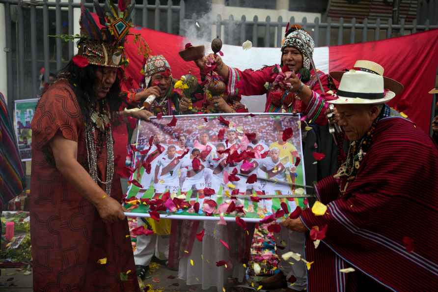 Peruvian shamans hold a poster of Peru's national soccer team while...