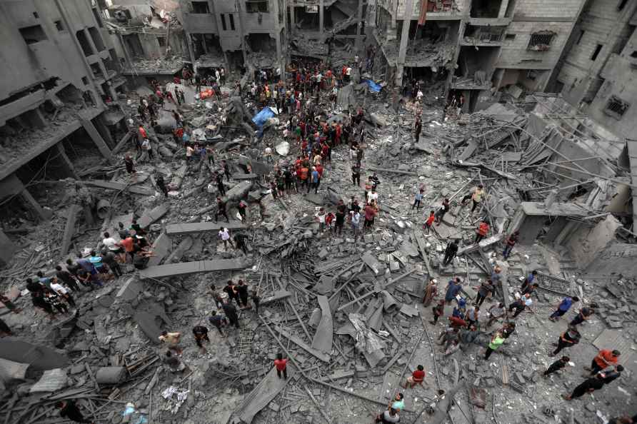 Palestinians inspect the damage of destroyed buildings