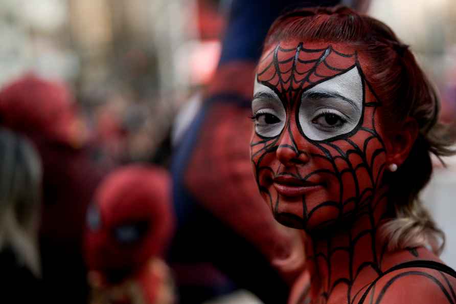 A woman painted as Spider-Man poses