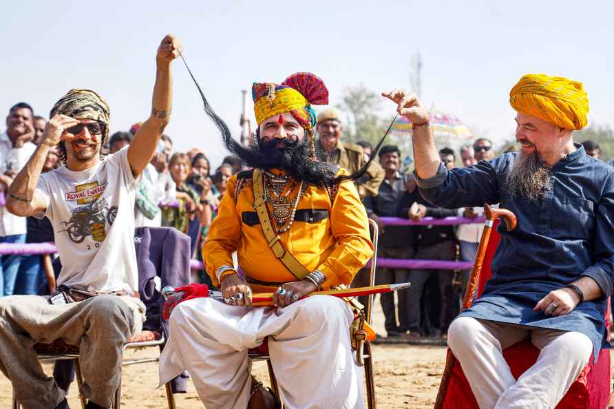 Pushkar: Foreign tourists with a participant of the 'longest moustache...