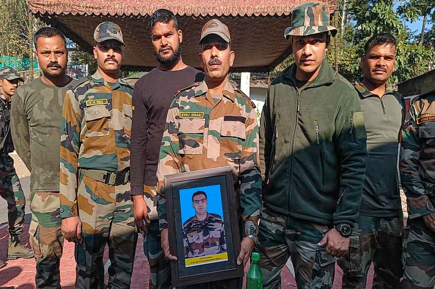 Rajouri: Indian Army personnel of Rashtriya Rifles hold the photograph...