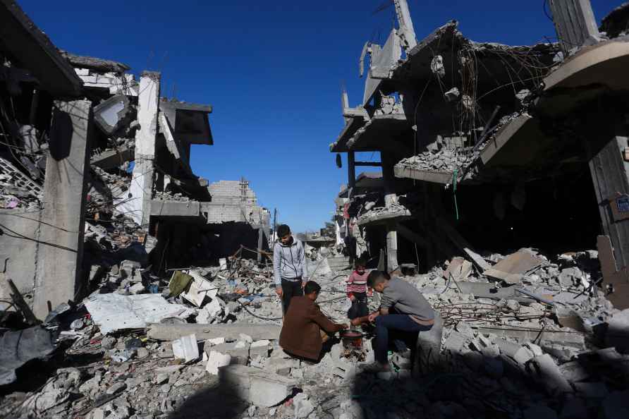 Palestinians cook bread by their destroyed homes