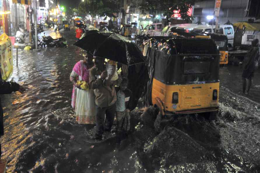 Chennai: Commuters make their way amid rain, in Chennai, Wednesday...