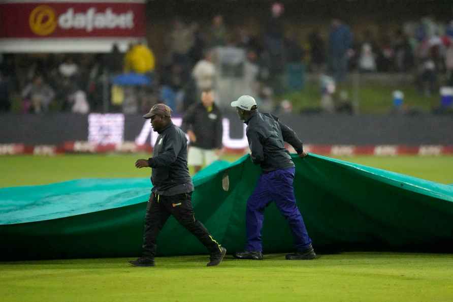 Ground workers pull rain covers as play is delayed during the second...