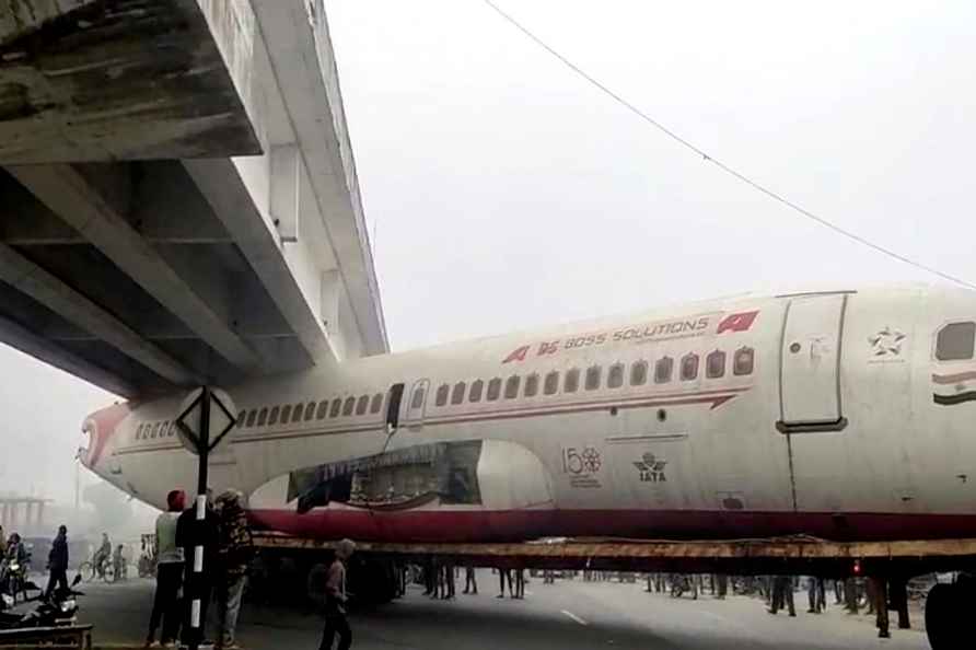 Scrap plane gets stuck under bridge