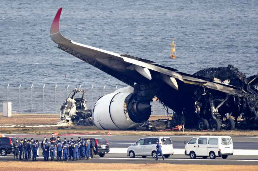 Police near wreckage of Japan Airlines plane