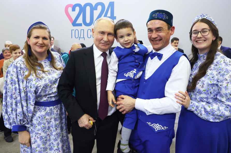 Russian President Vladimir Putin, center, poses for a photo with...