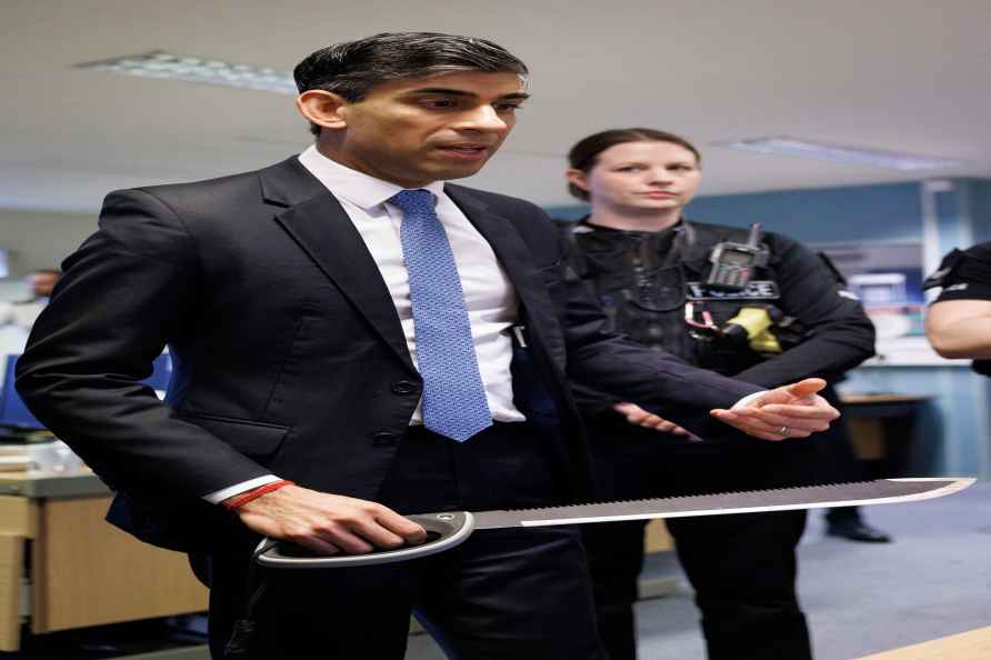 Britain's Prime Minister Rishi Sunak picks up a 'zombie knife' while...