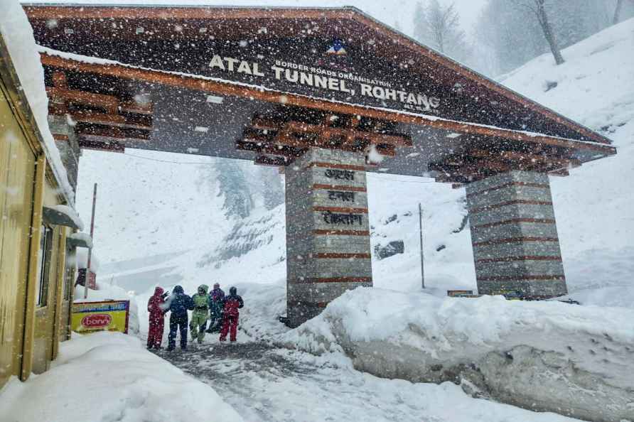 Manali: Tourists pose for photos amid snowfall at the south portal...