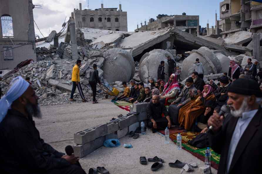 Palestinians pray in front of a mosque