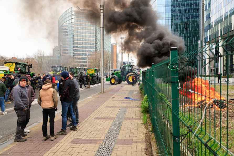 Farmers with their tractors stand on a main boulevard leading up...