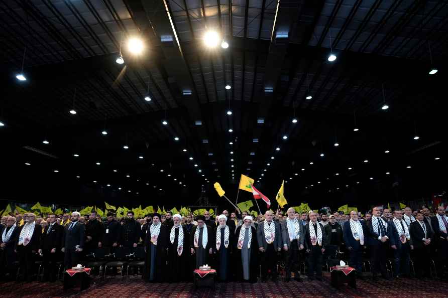 Hezbollah officials stand as they listen to the Lebanese national...