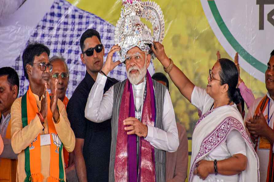 Malda: Prime Minister Narendra Modi being presented a crown during...