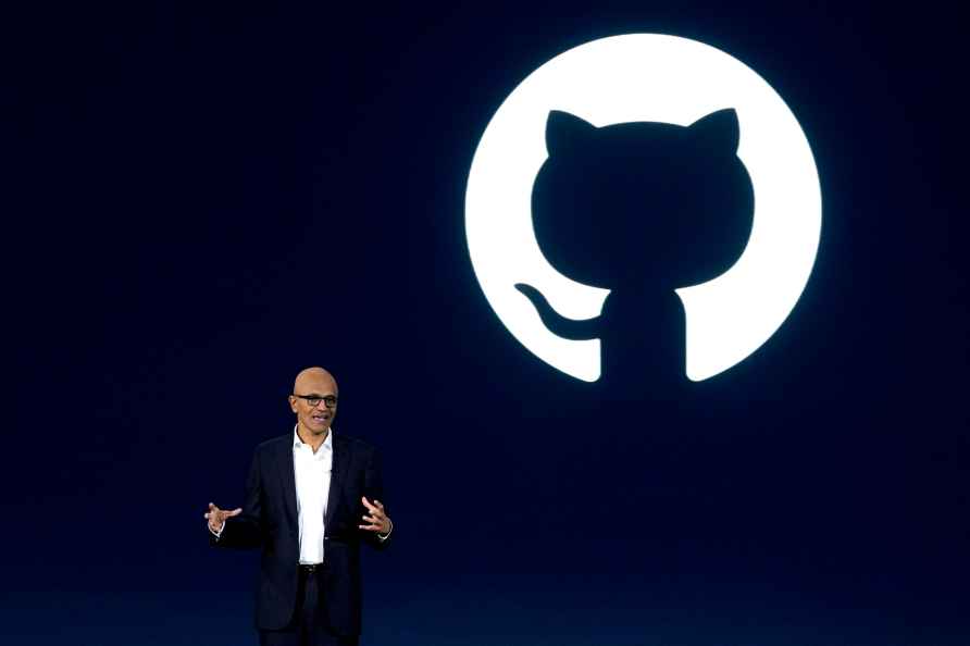 Microsoft CEO Satya Nadella speaks as the logo of Github, a subsidiary...