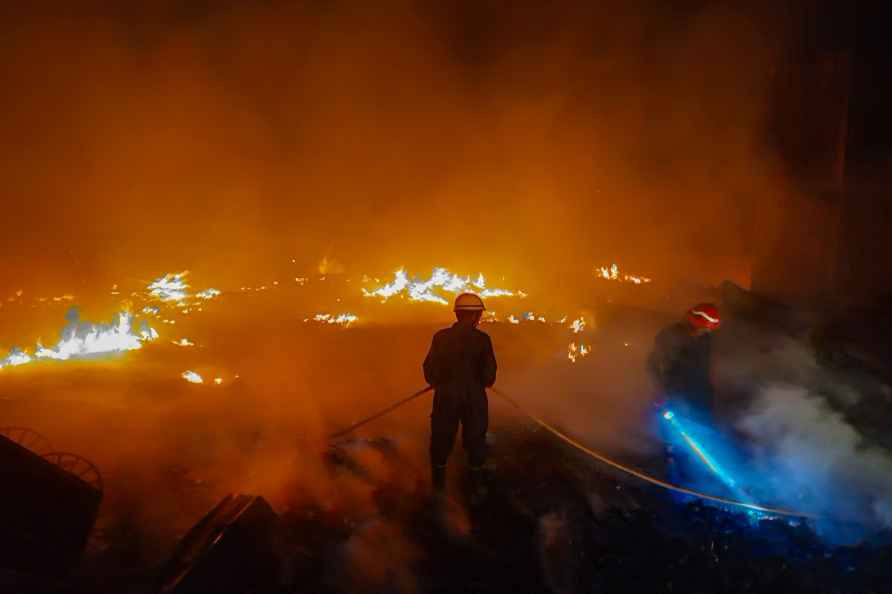 New Delhi: Firefighter douse a fire which broke out in a slum at...