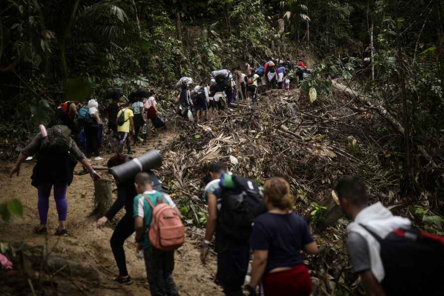 Migrants walk across the Darien Gap