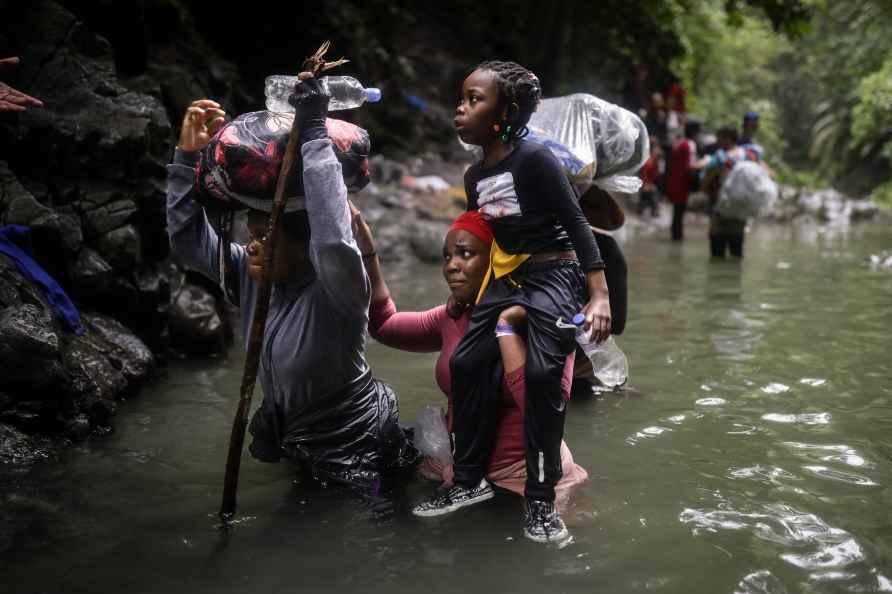 Haitian migrants wade through water