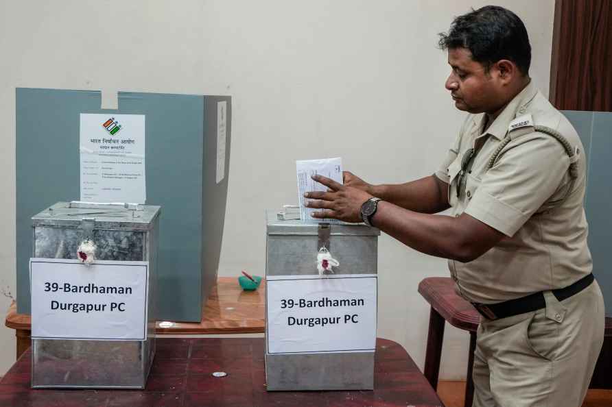 Bardhaman: A police official on election duty casts his vote via...