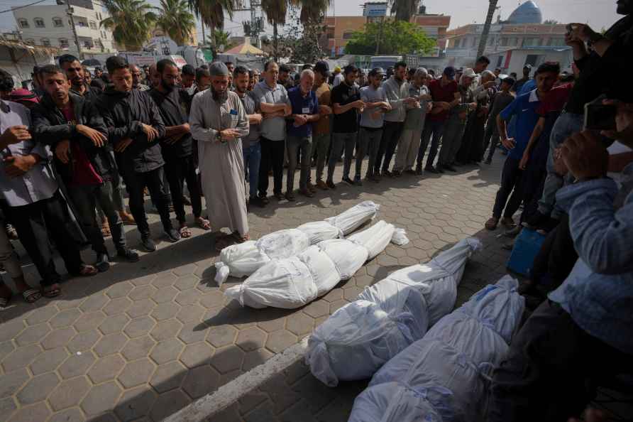 Mourners pray over the bodies of Palestinians who were killed in an Israeli airstrike in Nuseirat