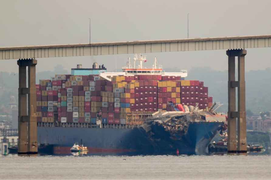 Tugboats escort the cargo ship Dali