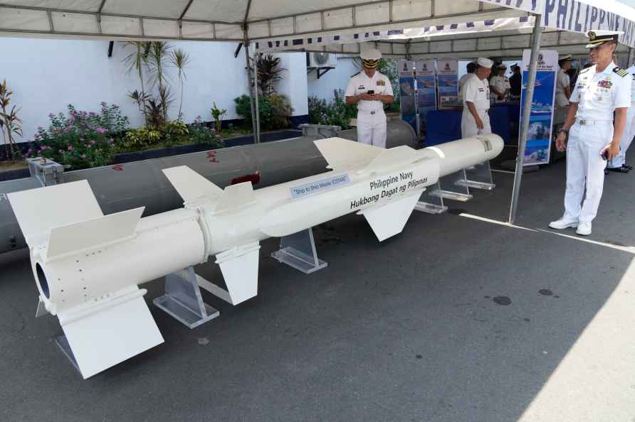 A Philippine Navy officer poses beside a ship to ship missile