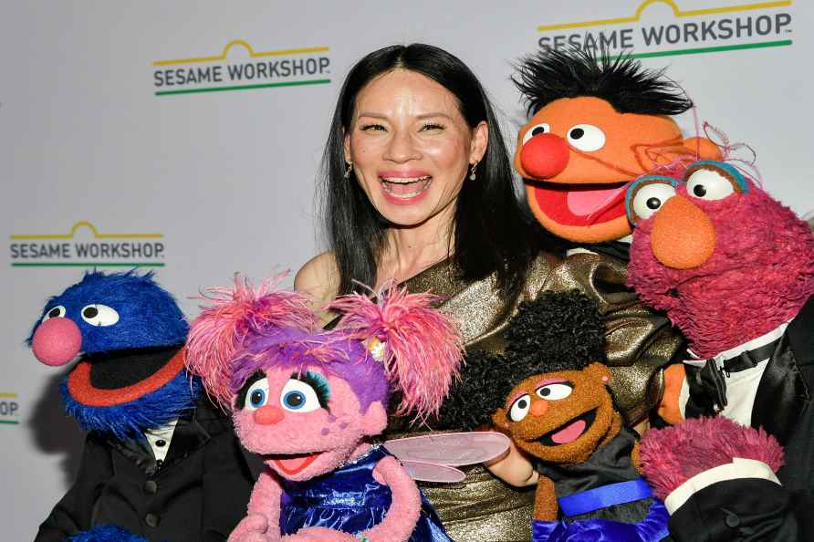 Lucy Liu, center, poses with Muppet characters at the Sesame Workshop...