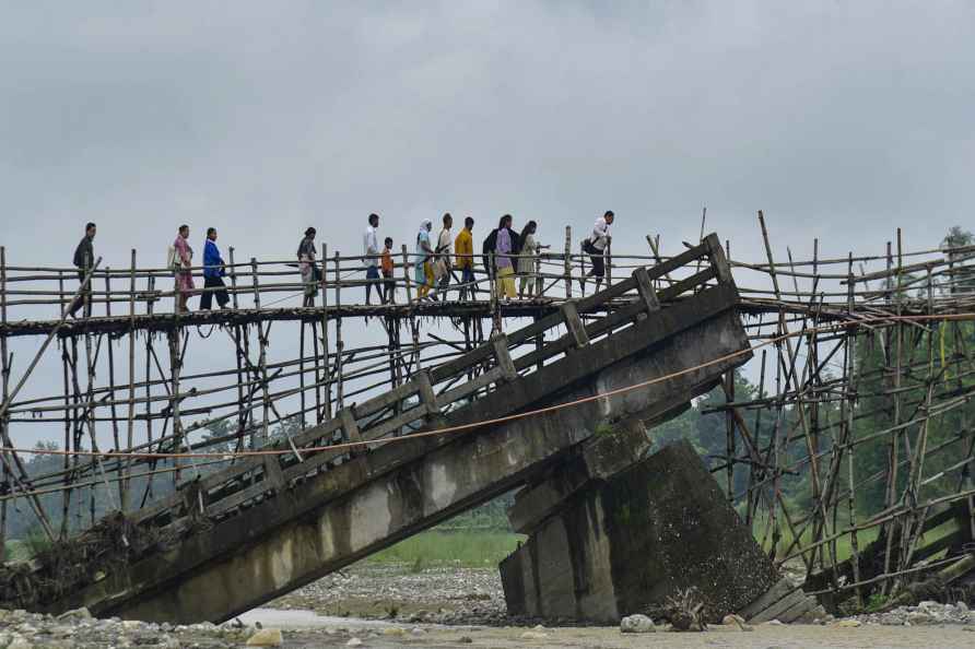 Baksa: Villagers use a temporary bamboo bridge to cross a river ...