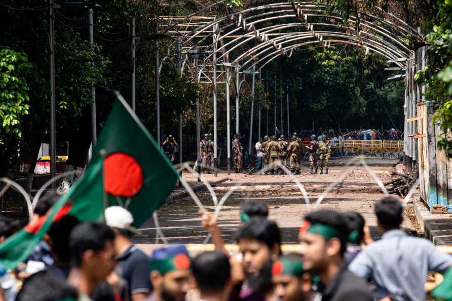 Military and paramilitary personnel stand guard as protesters block...